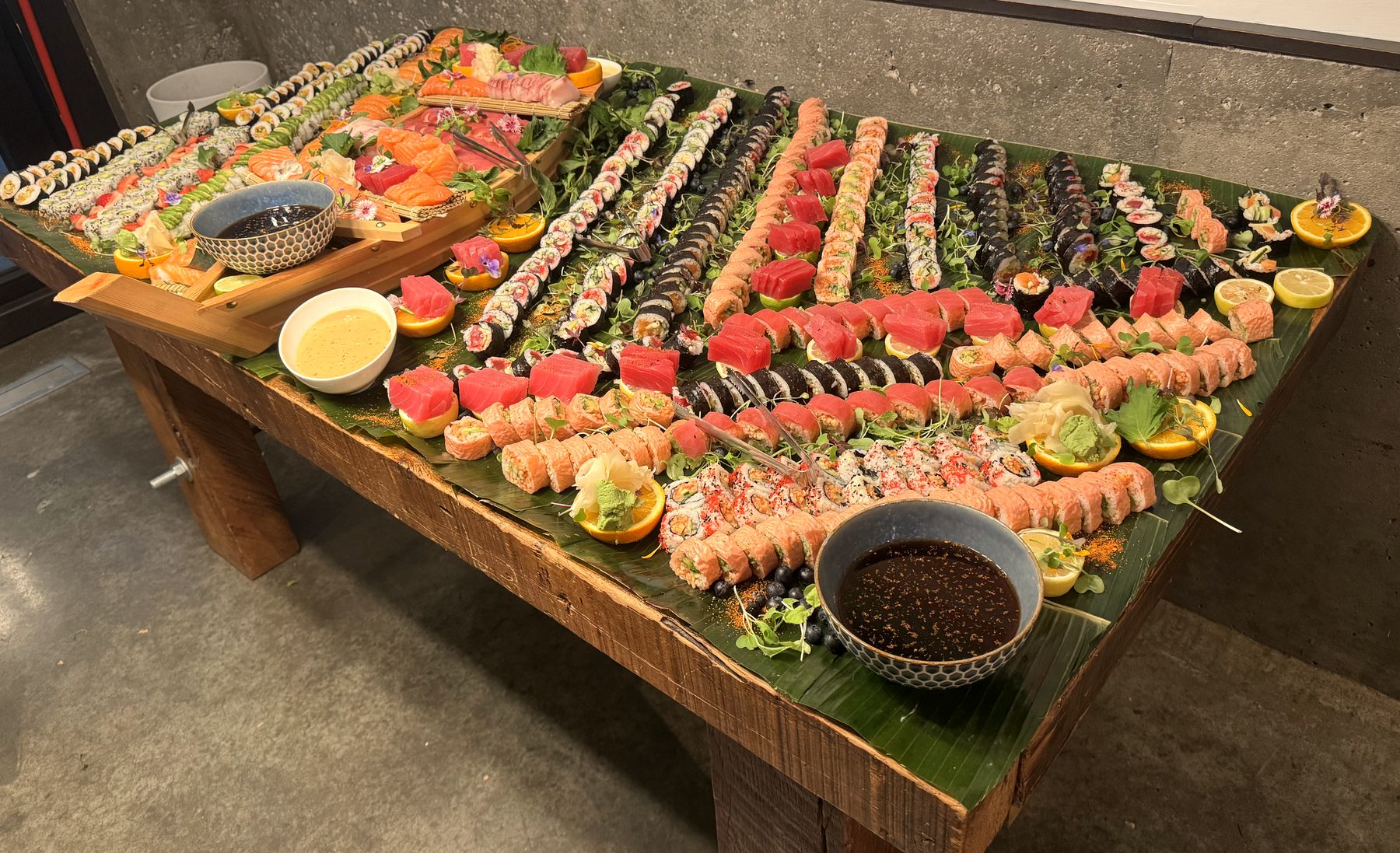 Table Sushika recouverte de feuilles de bananier et de rangées de sushis